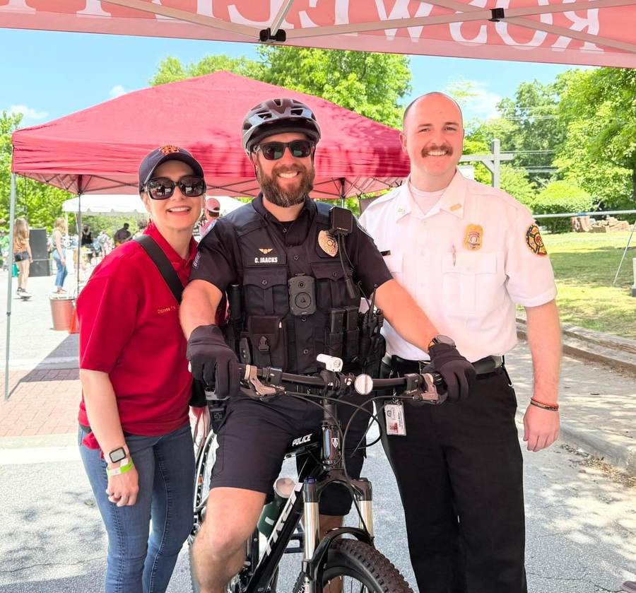 A Roswell Police bicycle officer with RFRF volunteers under the red Roswell tent.