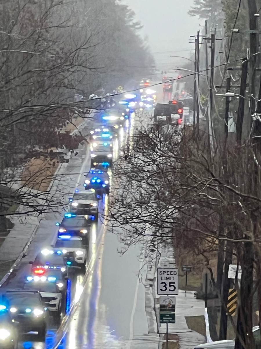 Roswell emergency vehicles in a winter procession through morning fog along a Roswell road.
