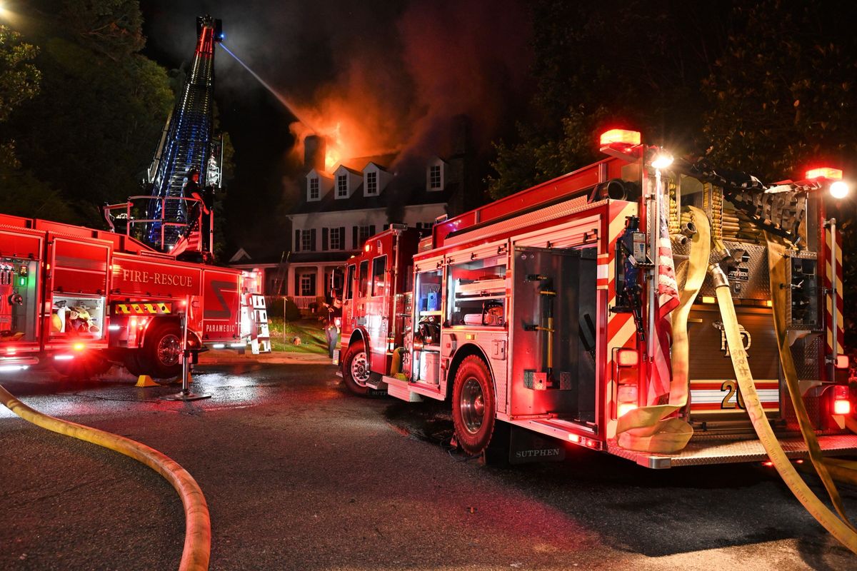 Roswell firefighters battling a structure fire at night, illuminated by emergency lights.