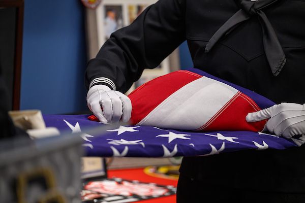 First responders ceremonially folding an American flag in honor of service and sacrifice.